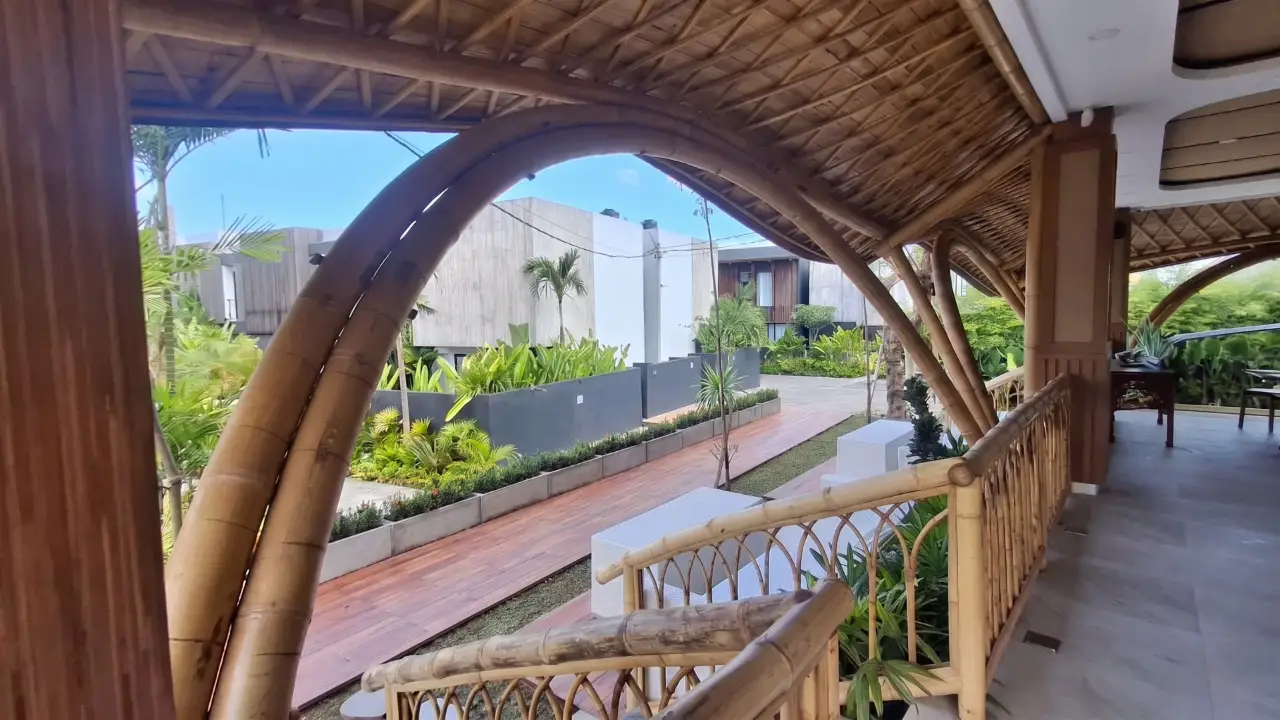 Biophilic Bali interior opening to a tropical garden through a curved bamboo arch