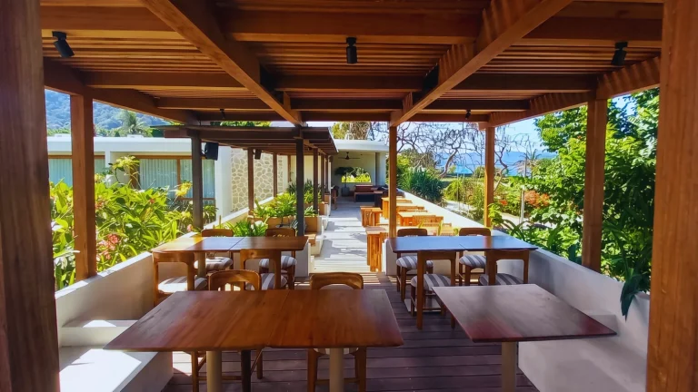 Rooftop restaurant terrace at Boni Beach Lombok with custom teak dining tables and chairs under a timber pergola