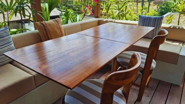 Custom teak communal dining table set against built in banquette seating at the Boni Beach Lombok rooftop restaurant