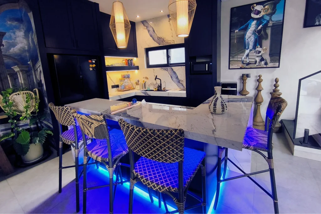 The completed Soho Blue villa kitchen in Kayu Tulang, Canggu, with dark navy cabinetry, a blue-veined marble bar counter and blue LED accent lighting, designed by Bali Best Design